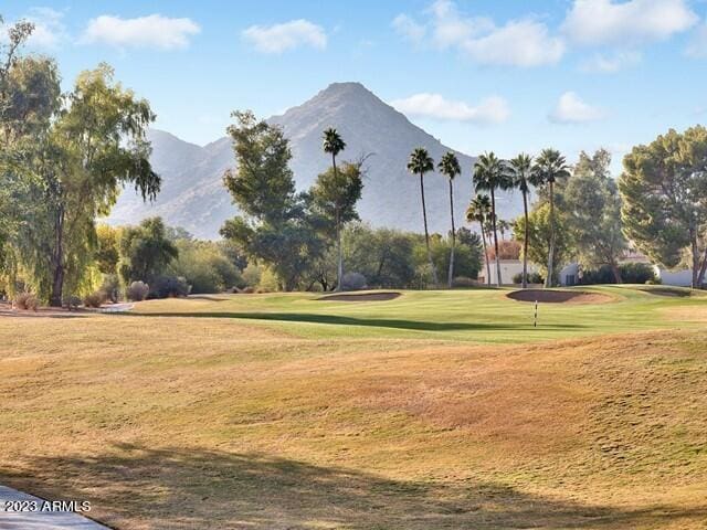 surrounding community with a mountain view and a yard