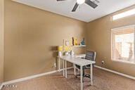 carpeted home office featuring ceiling fan