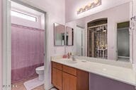 bathroom featuring vanity, a shower, and toilet