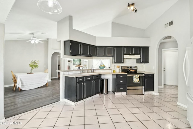 kitchen with sink, backsplash, stainless steel range with electric cooktop, and high vaulted ceiling