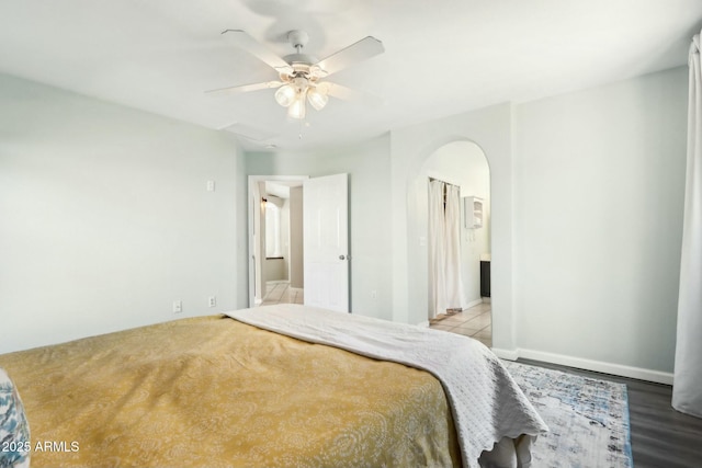 bedroom featuring light hardwood / wood-style flooring, ceiling fan, and ensuite bathroom