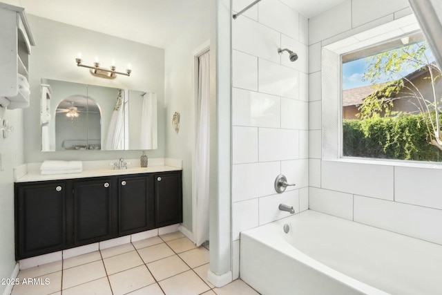 bathroom with tiled shower / bath combo, vanity, and tile patterned flooring