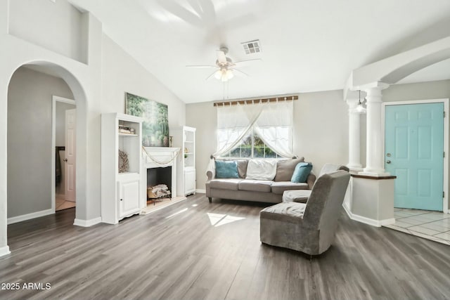 living room featuring decorative columns, vaulted ceiling, hardwood / wood-style floors, and ceiling fan