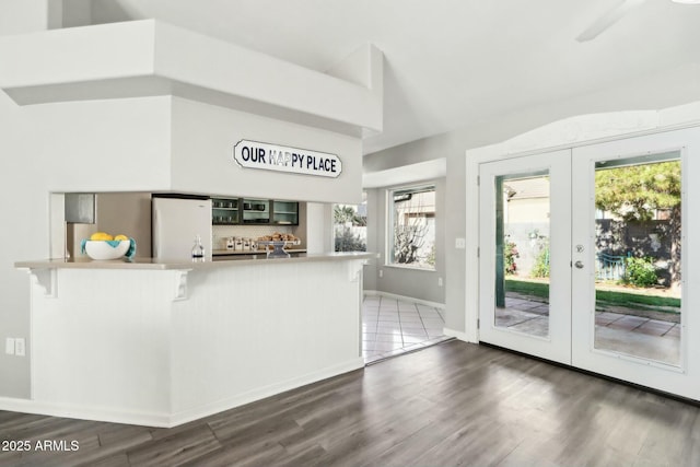 kitchen featuring french doors, plenty of natural light, a kitchen breakfast bar, kitchen peninsula, and white fridge