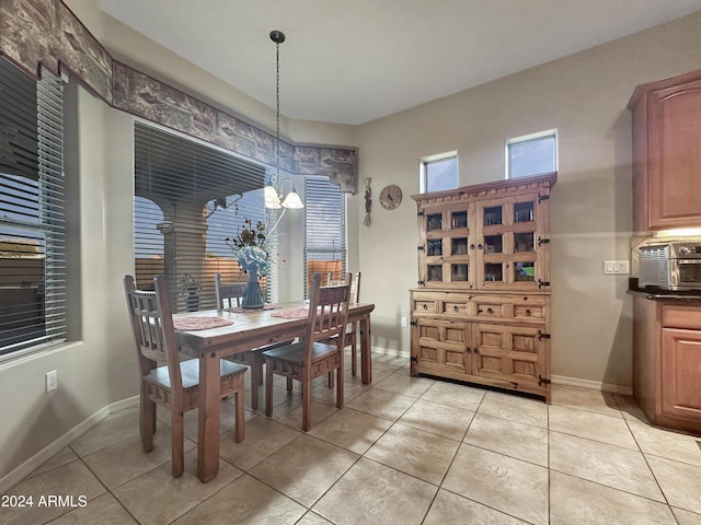 tiled dining area featuring a chandelier