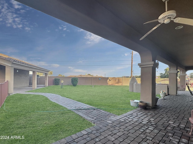 view of yard with ceiling fan and a patio area