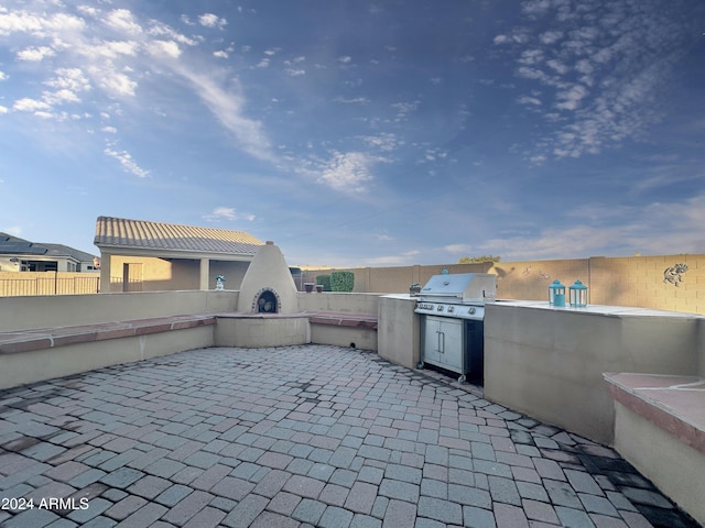 view of patio with an outdoor kitchen, area for grilling, and a tile fireplace