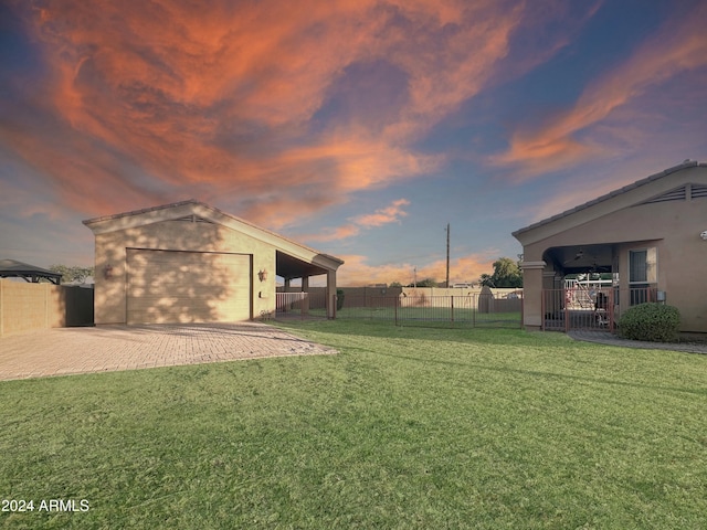 yard at dusk with an outbuilding and a garage