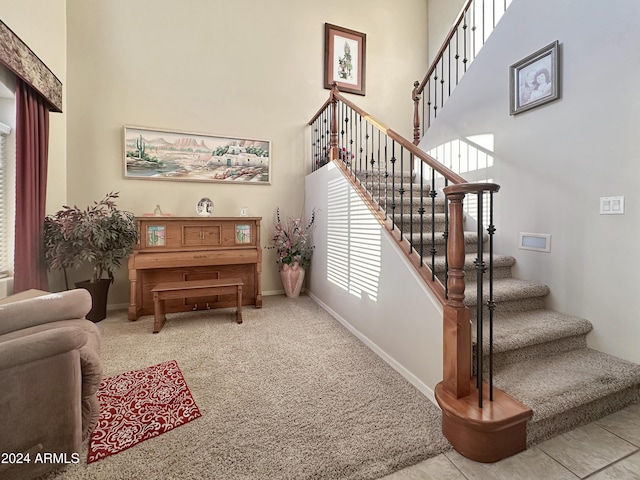 stairway featuring carpet flooring and a high ceiling