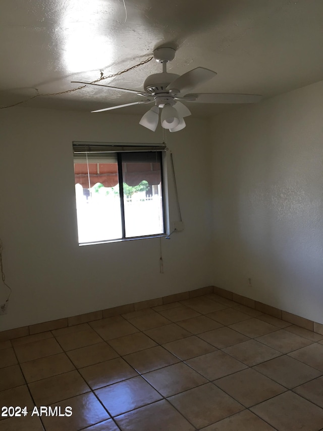 spare room featuring tile patterned floors and ceiling fan