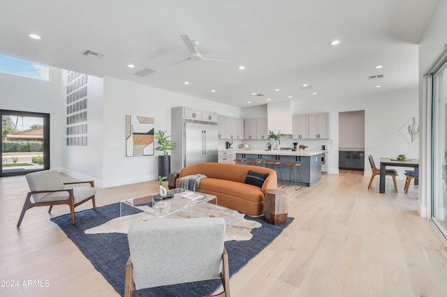 living room featuring ceiling fan and light hardwood / wood-style floors