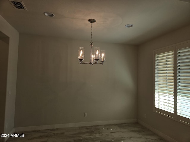 unfurnished room featuring a notable chandelier