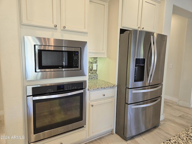 kitchen featuring light stone countertops and appliances with stainless steel finishes