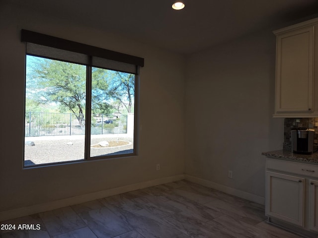 unfurnished dining area featuring plenty of natural light