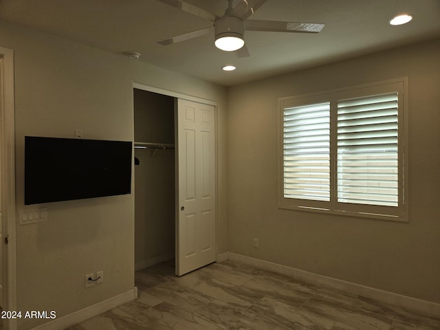 unfurnished bedroom with ceiling fan and a closet