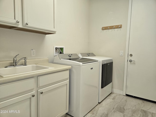 laundry area featuring cabinets, washer and clothes dryer, and sink