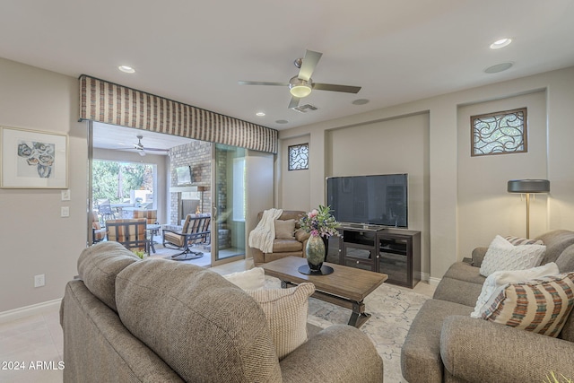 living room featuring light tile patterned flooring, ceiling fan, and a fireplace