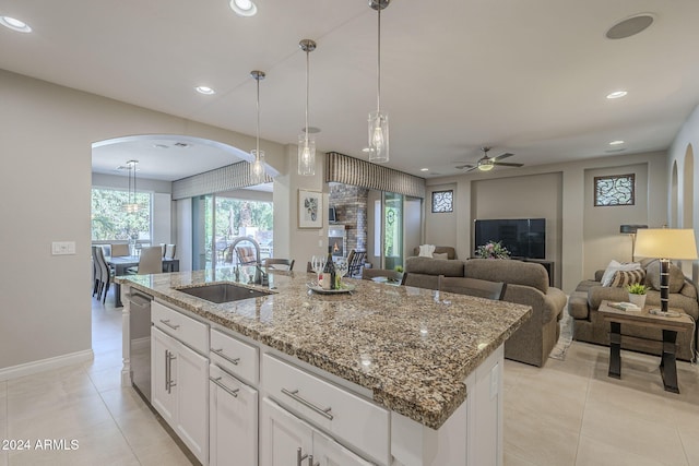 kitchen featuring white cabinetry, an island with sink, sink, and pendant lighting