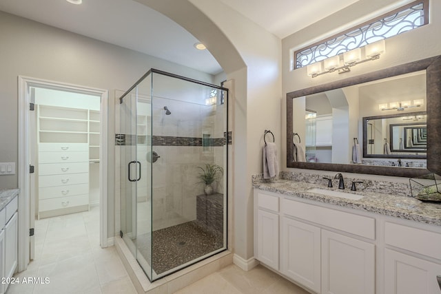 bathroom with tile patterned flooring, vanity, and a shower with shower door