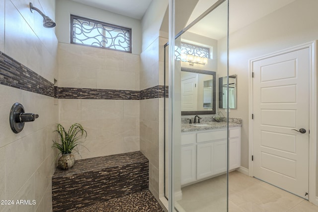 bathroom featuring tiled shower and vanity