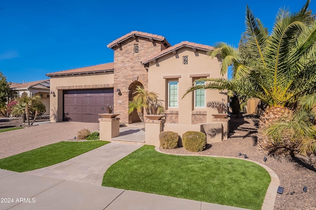 mediterranean / spanish-style home featuring a garage and a front lawn