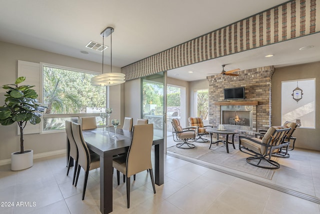 dining area featuring a brick fireplace and light tile patterned floors