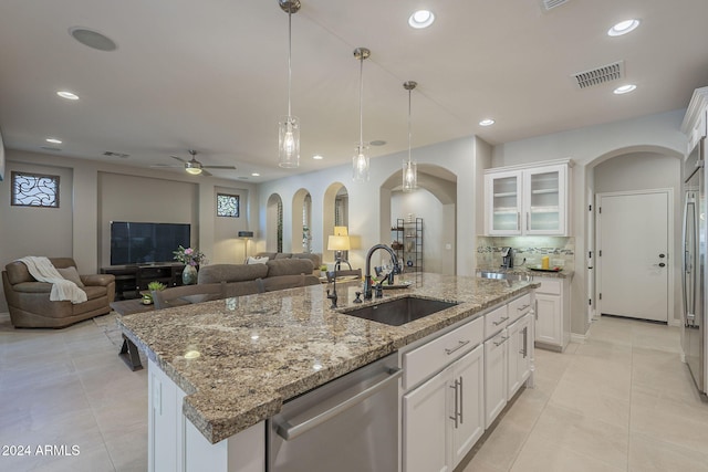 kitchen with white cabinetry, an island with sink, dishwasher, and sink