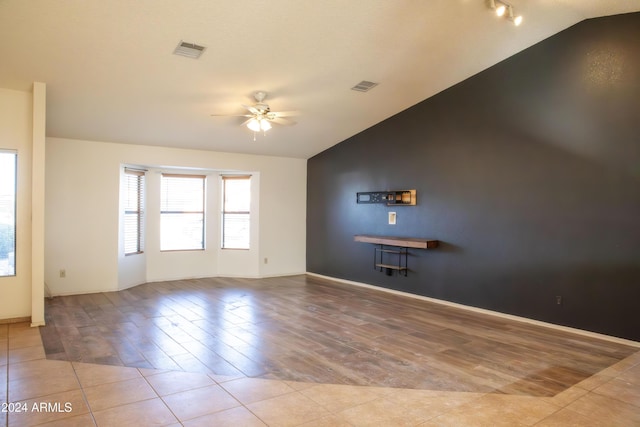 tiled empty room with ceiling fan and lofted ceiling