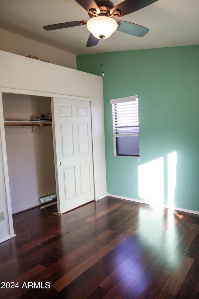 unfurnished bedroom featuring ceiling fan, dark hardwood / wood-style flooring, and a closet