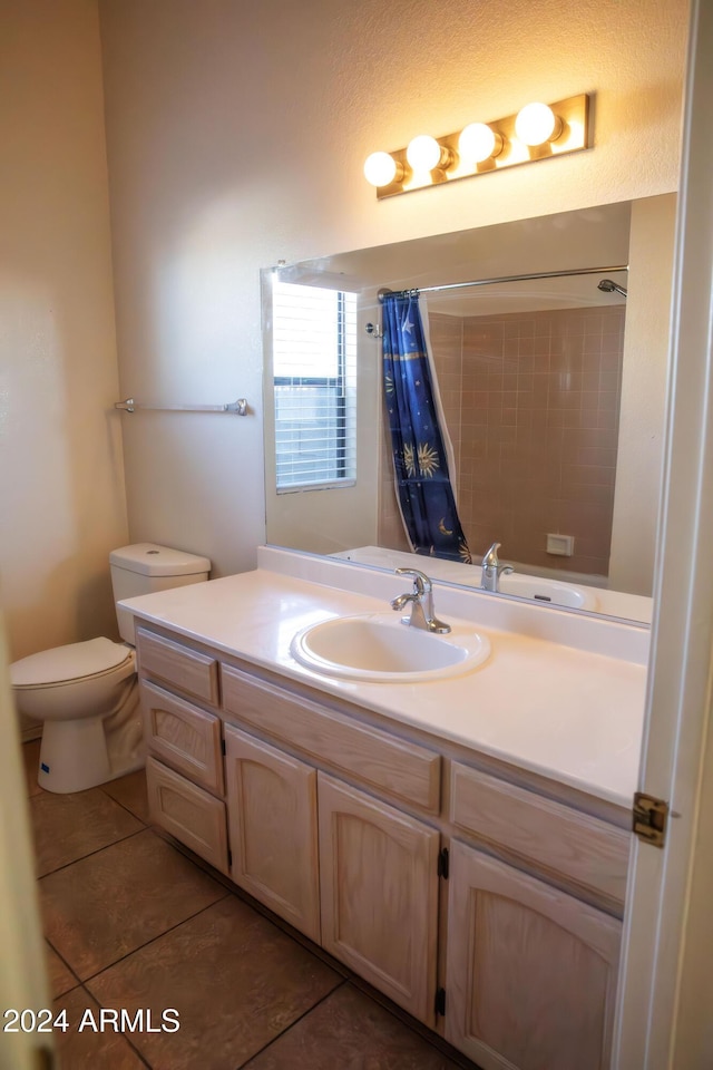 bathroom featuring a shower with shower curtain, vanity, tile patterned floors, and toilet