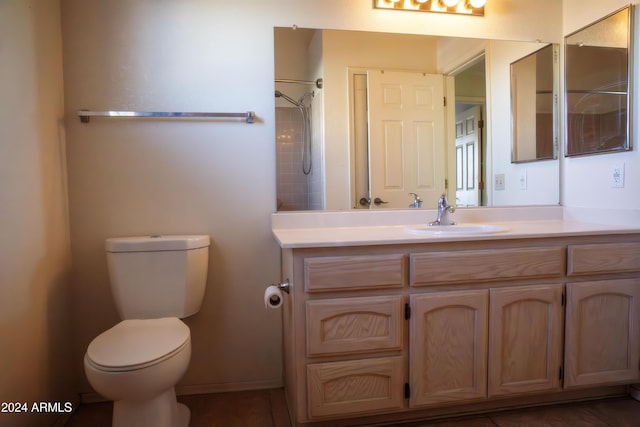 bathroom with vanity, toilet, and a shower