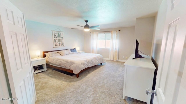 bedroom with a ceiling fan, light colored carpet, a textured ceiling, and baseboards