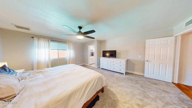 bedroom with baseboards, visible vents, connected bathroom, light colored carpet, and ceiling fan