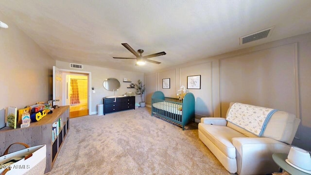 living area with visible vents, ceiling fan, and light carpet