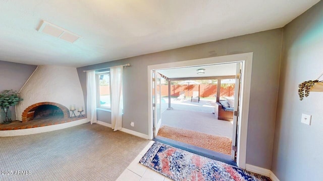 doorway to outside featuring a brick fireplace, carpet flooring, and baseboards