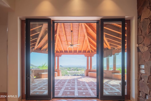 doorway featuring a healthy amount of sunlight and lofted ceiling with beams