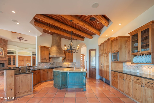 kitchen with backsplash, custom range hood, ceiling fan, and beamed ceiling