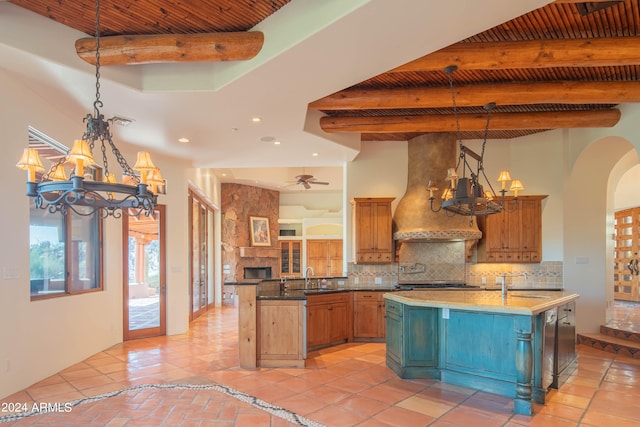 kitchen with beamed ceiling, light tile floors, and an island with sink