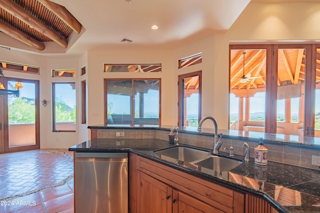 kitchen featuring stainless steel dishwasher, sink, tasteful backsplash, and a wealth of natural light