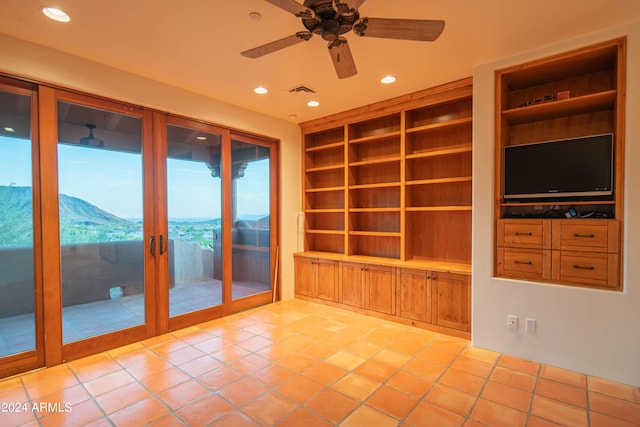 tiled spare room featuring ceiling fan, a mountain view, and built in features