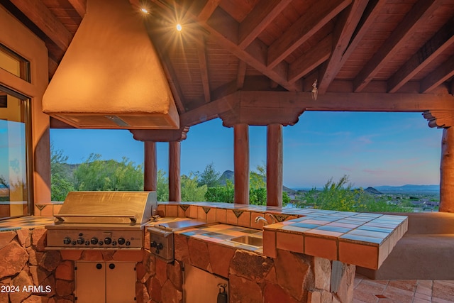 patio terrace at dusk with exterior kitchen and grilling area