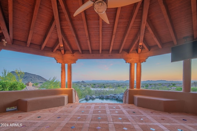 patio terrace at dusk with a mountain view and ceiling fan