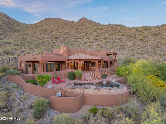 rear view of property featuring a patio area and a mountain view