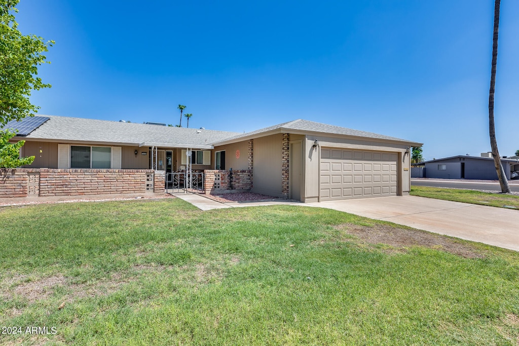 ranch-style house featuring a front yard and a garage