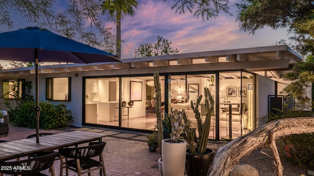 5714 N 11th St, Phoenix, AZ 85014 - back of house at dusk featuring a patio, outdoor dining space, and stucco siding