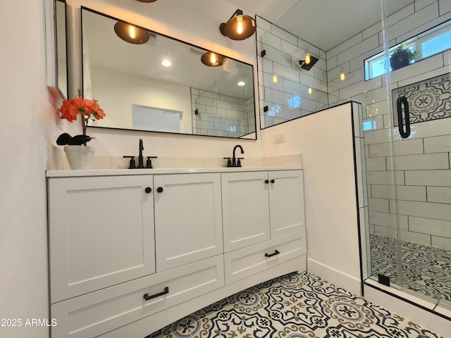 bathroom with walk in shower, vanity, and tile patterned flooring