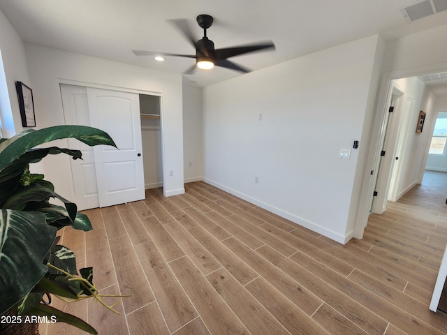 bedroom with ceiling fan, light hardwood / wood-style floors, and a closet