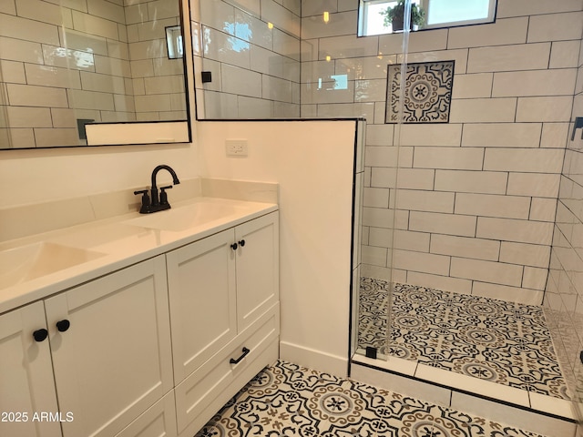 bathroom featuring tile patterned floors, vanity, and a tile shower