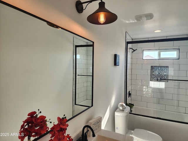 full bathroom featuring sink, bath / shower combo with glass door, and toilet