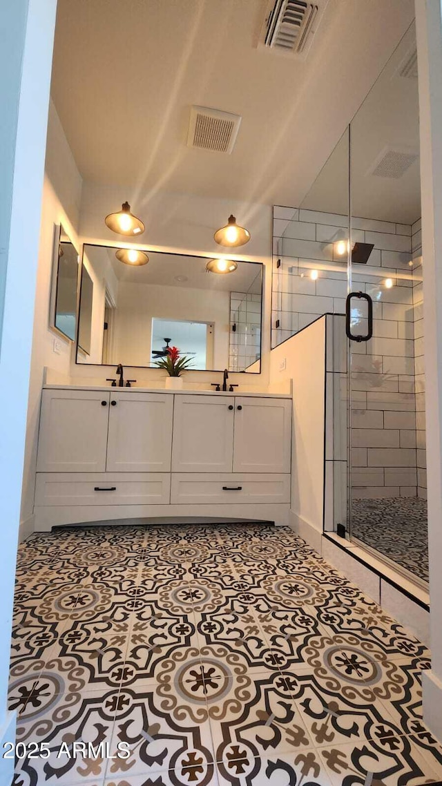 bathroom featuring walk in shower, vanity, and tile patterned flooring